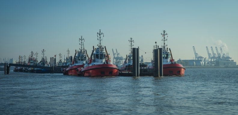 Towing boats in the harbor of Hamburg_shutterstock_1562614105