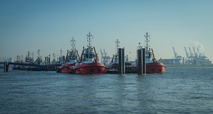 Towing boats in the harbor of Hamburg_shutterstock_1562614105