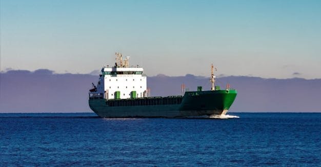 Green cargo ship moving in still water of Baltic sea_shutterstock_601335962