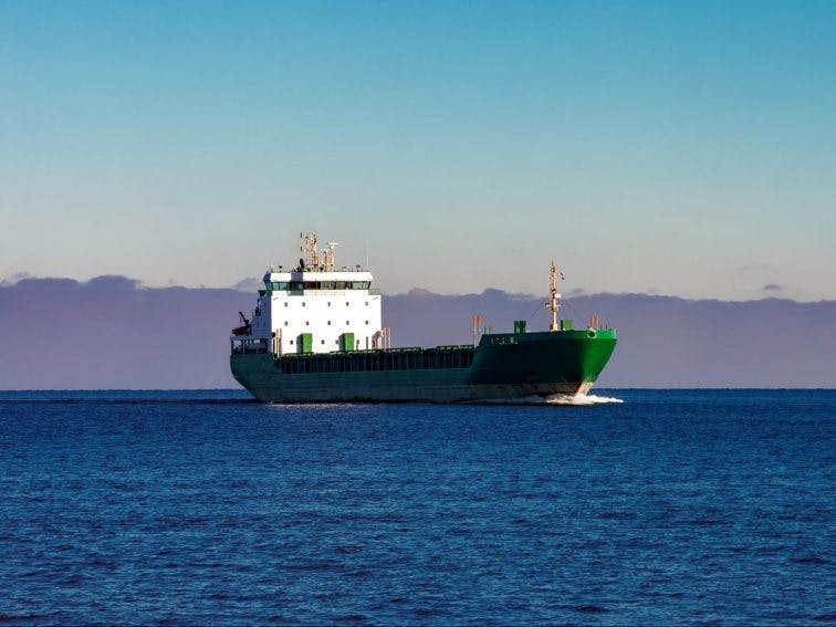 Green cargo ship moving in still water of Baltic sea_shutterstock_601335962
