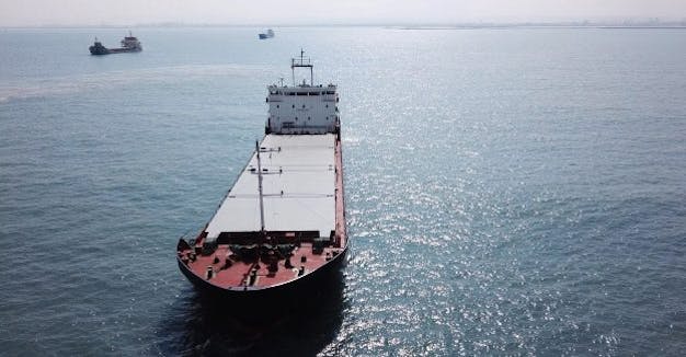 Large bulk carrier general cargo ship sailing / docking in open ocean_shutterstock_707658898